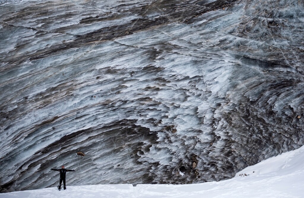 A tourist poses for a picture on the Bogdanovich glacier located in the Tian Shan mountain range near Almaty, Kazakhstan February 20, 2021. Picture taken February 20, 2021. REUTERS/Pavel Mikheyev TPX IMAGES OF THE DAY - RC2OZL9KPUY3