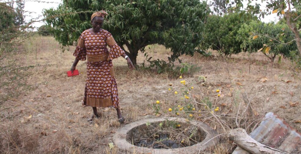 Beatrice Ndavi points to a dried-up well on her farm in Masii village, Machakos County, Kenya, on August 29, 2019. Thomson Reuters Foundation/Wesley Langat
