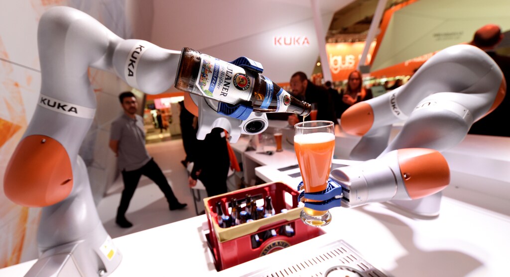 A robotic arm fills a glass with Bavarian Weiss beer at the booth of German company Kuka at the world's biggest industrial fair, "Hannover Fair", in Hanover, Germany April 24, 2017. REUTERS/Fabian Bimmer