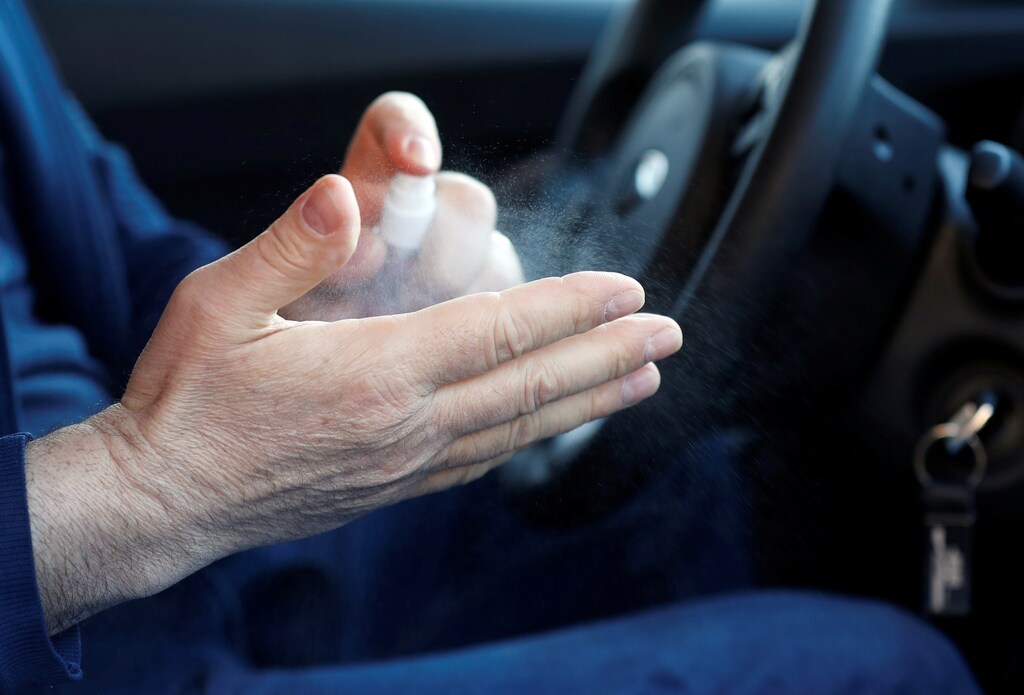 Francesco Seminario, a taxi driver, sanitises his hands in his taxi in Milan, Italy February 28, 2020. Taxis have been losing business since Italy's coronavirus outbreak. REUTERS/Yara Nardi - RC2S9F9M3KV0