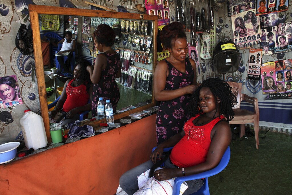 A woman gets her hair done at a salon in Juba, March 8, 2014. On March 8 activists around the globe celebrate International Women's Day, which dates back to the beginning of the 20th Century and has been observed by the United Nations since 1975. The UN writes that it is an occasion to commemorate achievements in women's rights and to call for further change. REUTERS/Andreea Campeanu (SOUTH SUDAN - Tags: SOCIETY) - RTR3G8RG