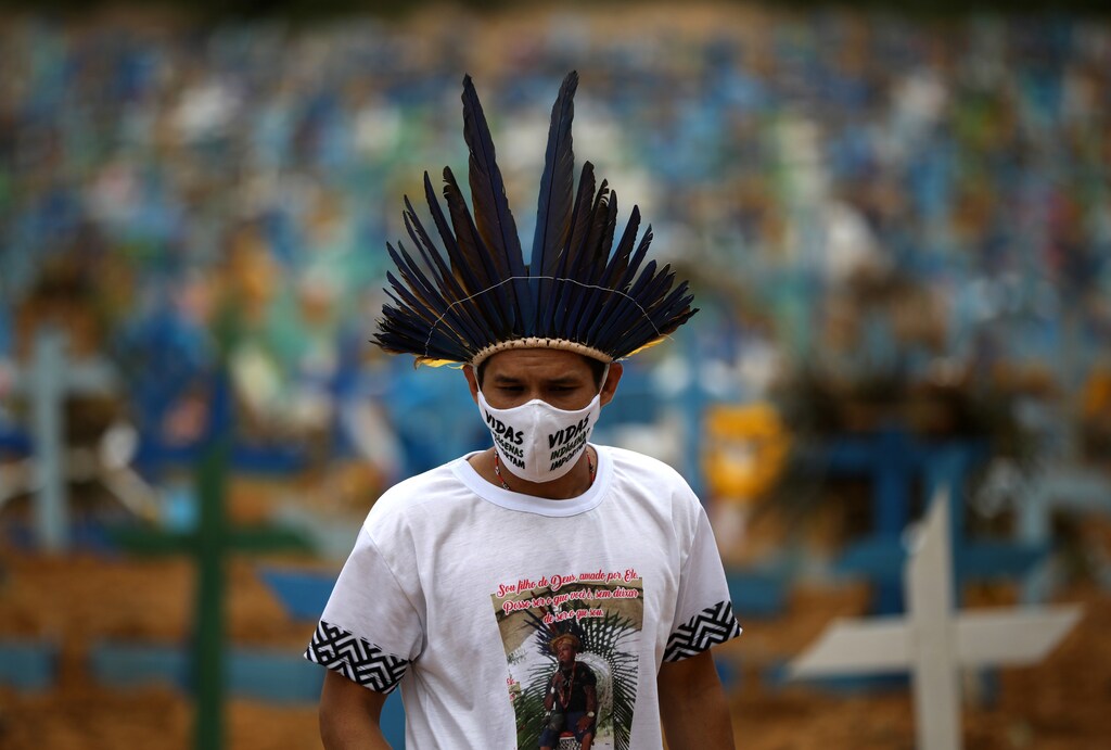 Indigenous person Miqueias Moreira Kokama, wears a protective face mask with words that read:"Indigenous lives matter", during a visit to his father's grave, indigenous Chief Messias Kokama, who passed away due to the coronavirus disease (COVID-19), at the Parque Taruma cemetery in Manaus, Brazil, May 26, 2020. REUTERS/Bruno Kelly - RC2IWG9QOGAR
