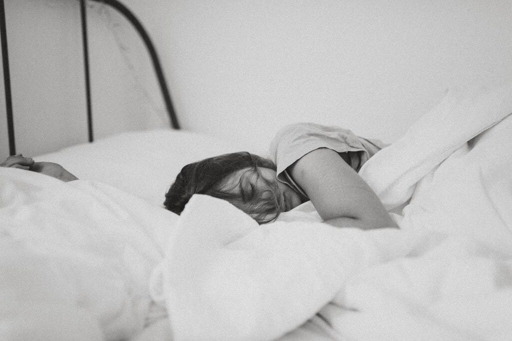 Sleep training: A person lying in bed asleep.