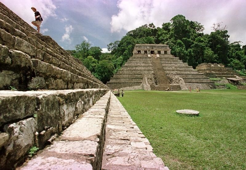 TO GO WITH BC-MEXICO-ARCHEOLOGY - A tourist climbs up the side of one of Palenque's Maya pyramids August 14. Palenque, considered the jewel in the crown of the Maya world, stretches over an area of 20 square kilometres, of which only 20% has been uncovered. Over 100 buildings have been documented, but unexplored, in the thick jungle in which the Maya city is set. During excavation of one of these unexplored sites, archeologists believe they have uncovered the first image of Palenque's only undocumented leader from the period of AD 732 to 764 from which they had no previous references. They believe the figure to be the missing leader of this undocumented period due to regal glyphs and glyphs dating the figure to the period in question.AW/AA - RP1DRIFVRCAB