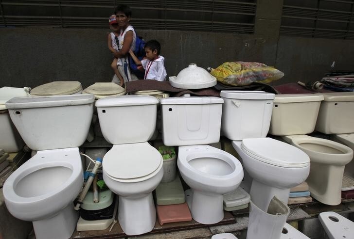 A woman walks past a row of recycled toilet bowls for sale at 1,500 pesos ($34) each along a major street in Manila November 19, 2014. The United Nations General Assembly has declared November 19 as World Toilet Day to raise awareness about the need for all human beings to have access to sanitation. REUTERS/Romeo Ranoco (PHILIPPINES - Tags: SOCIETY)