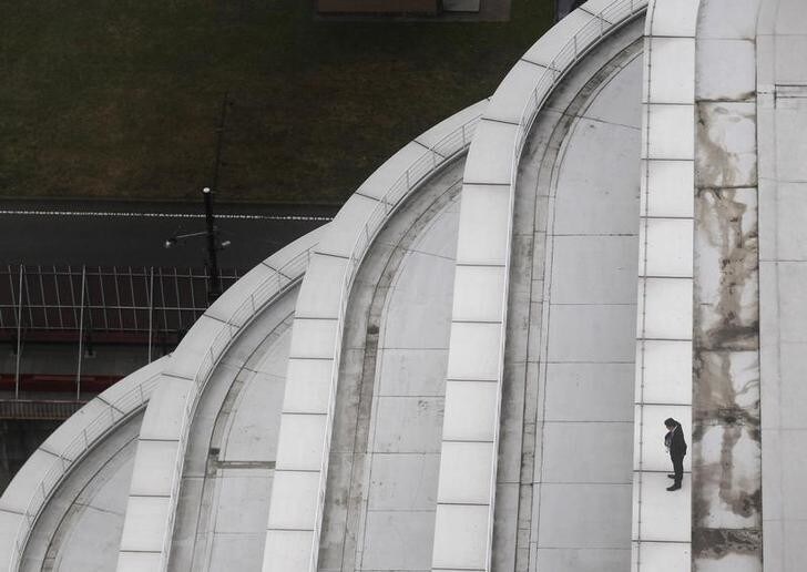 A man looks out over the area from the roof of a building inside the perimeter at the APEC Summit in Yokohama November 14, 2010. REUTERS/Jim Young (JAPAN - Tags: POLITICS IMAGES OF THE DAY)