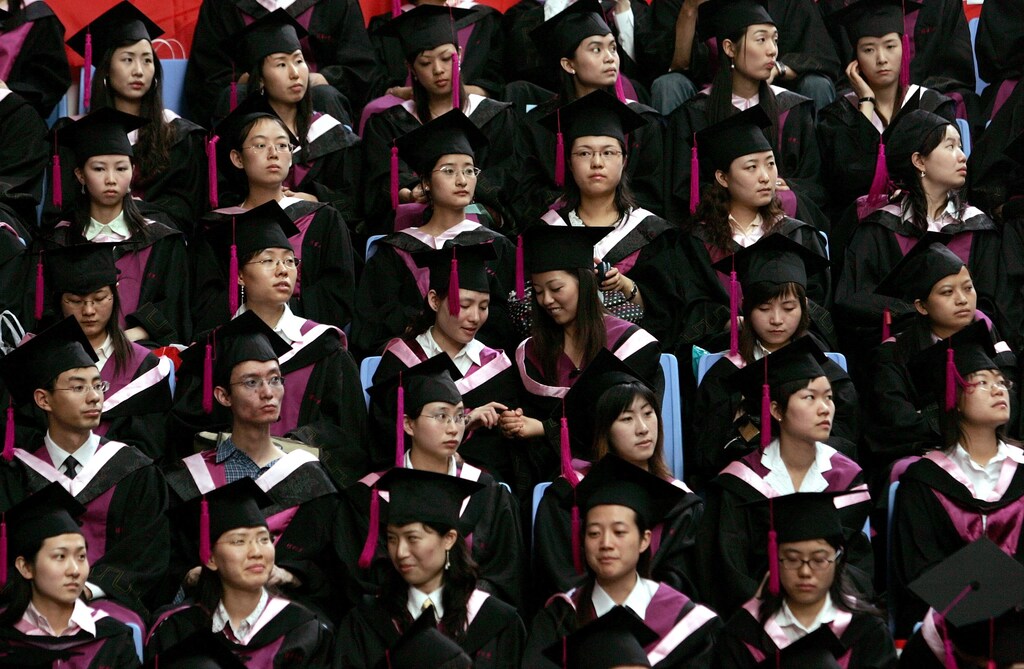 Two graduates play during a graduation ceremony at Tsinghua University in Beijing, July 11, 2006. About 4.1 million are expected to graduate this year, an increase of 22 percent over 2005, the official Xinhua news agency reported. REUTERS/Jason Lee (CHINA) - RTR1FDWL