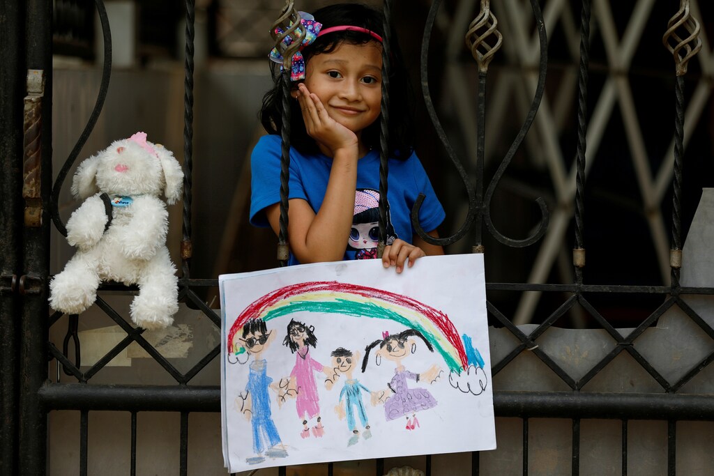 Jemima Christa-Faelist Tanamal, 6, poses for a photograph while holding a picture that she drew during the coronavirus disease (COVID-19) outbreak, while standing by her grandparents house in Bekasi, Indonesia, April 21, 2020. Jemima drew herself and her little brother going for a picnic with their grandparents. "I don't like to stay at home, boring," said Jemima. "Once I can go outside, I will go to the mini-market for bubble gum first. I like to go to school, because I can play together with my friends. I will hug my friends and teachers when I go back to school later and say 'I miss you teacher, I miss you friend' to them." REUTERS/Willy Kurniawan SEARCH "CORONAVIRUS DRAWING" FOR THIS STORY. SEARCH "WIDER IMAGE" FOR ALL STORIES. REFILE - CLARIFYING INFORMATION - RC2BAG9LYF2Z