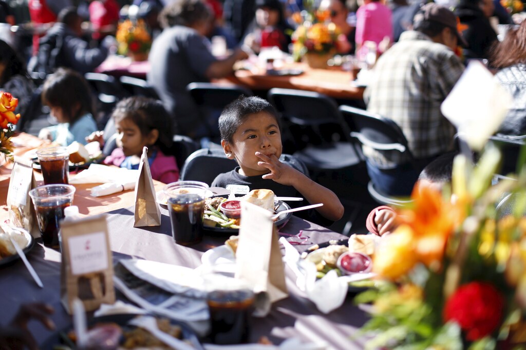 A boy eats an early Thanksgiving meal served to the homeless at the Los Angeles Mission in Los Angeles, California, November 25, 2015.