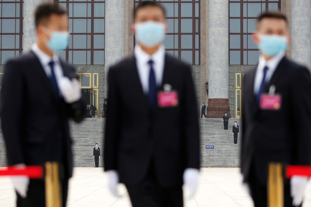 Security personnel wearing face masks following the coronavirus disease (COVID-19) outbreak stand guard outside the Great Hall of the People before the opening session of the Chinese People's Political Consultative Conference (CPPCC) in Beijing, China May 21, 2020. REUTERS/Carlos Garcia Rawlins - RC2USG9B4EIZ