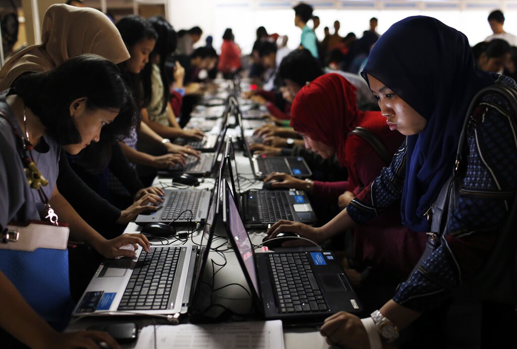ノートPCに向かう大勢の若い労働者。若者の主体性への投資は、これに投資する意思のある企業にとって潜在的な戦略的優位性をもたらします。