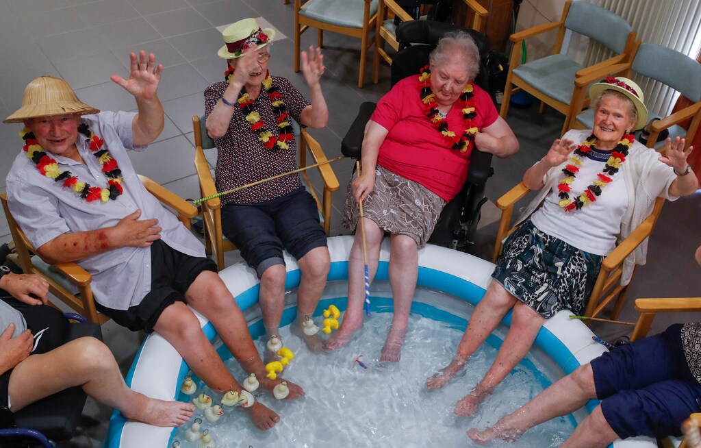 Residents at the Ter Biest house for elderly persons refresh their feet in a pool on a hot summer day, in Grimbergen, Belgium, August 3, 2018. REUTERS/Yves Herman - RC123F5D8240
