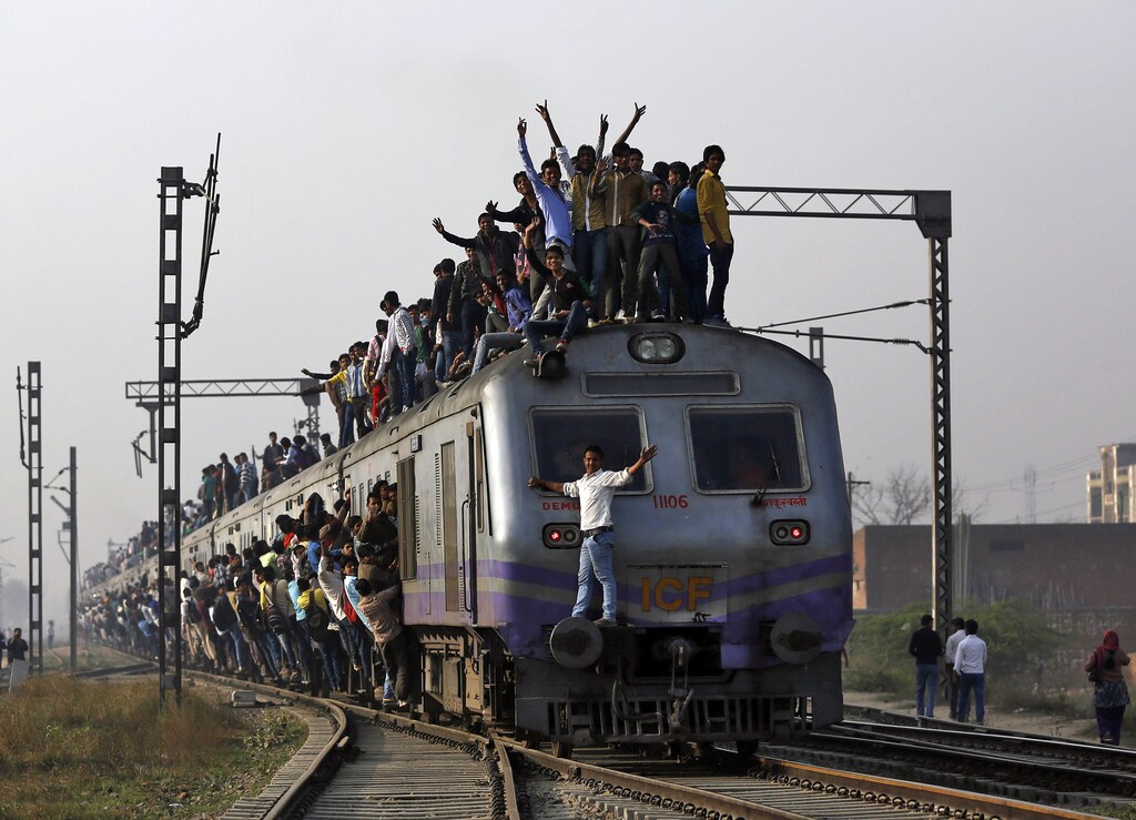 Passengers travel on an overcrowded train on the outskirts of New Delhi February 26, 2015. India will increase investment in its overloaded railway network to 8.5 trillion rupees ($137 billion) over the next five years, the government said on Thursday, promising to modernise existing tracks and introduce faster trains. REUTERS/Ahmad Masood (INDIA - Tags: BUSINESS TRANSPORT POLITICS TPX IMAGES OF THE DAY) - GM1EB2Q19AH01