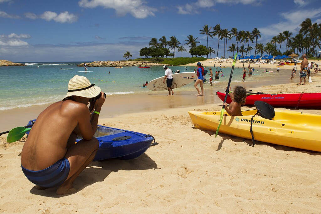 Mike Wilson takes a picture of his son playing in a kayak on the beach as two hurricanes approach the Hawaiian islands, in Honolulu, Hawaii, August 6, 2014. Hawaiians braced for a one-two punch from a pair of major storms headed their way on Wednesday, as Hurricane Iselle bore down on the islands packing high winds and heavy surf and Julio, tracking right behind, was upgraded to hurricane status. REUTERS/Hugh Gentry (UNITED STATES - Tags: ENVIRONMENT DISASTER SOCIETY) - RTR41I39