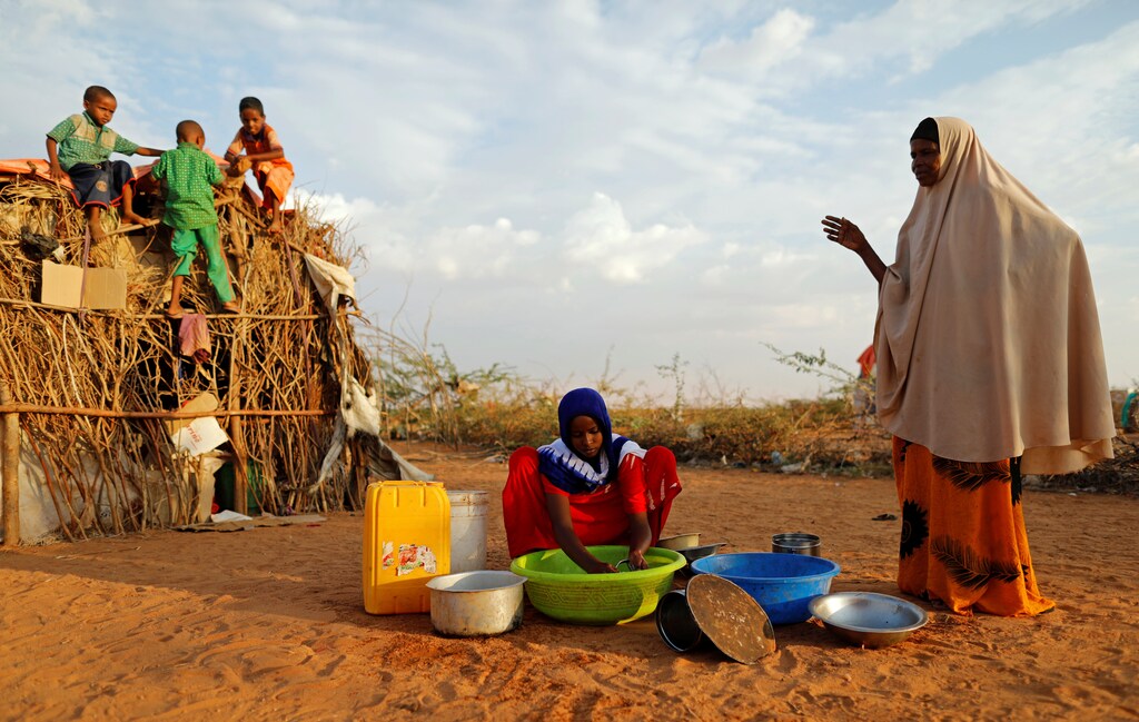 Zeinab, 14, (C) washes dishes as her mother Abdir Hussein gestures and her nephews play at a camp for internally displaced people from drought hit areas in Dollow, Somalia April 3, 2017. REUTERS/Zohra Bensemra SEARCH "ZEINAB DOLLOW" FOR THIS STORY. SEARCH "WIDER IMAGE" FOR ALL STORIES. - RTX34W4Z