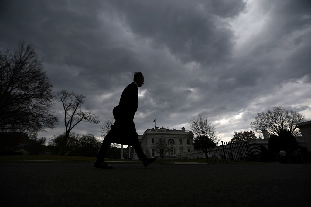A man walks on the North Lawn of the White House as a thunderstorm approaches the Washington D.C. area in Washington, U.S., March 1, 2017. REUTERS/Carlos Barria - RTS110LW