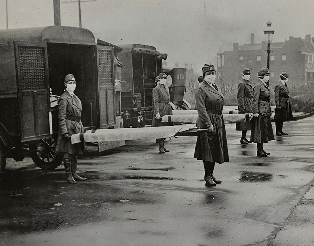 Mask-wearing women hold stretchers near ambulances during the Spanish Flu pandemic in St. Louis, Missouri, U.S. in October 1918. Library of Congress/Handout via REUTERS THIS IMAGE HAS BEEN SUPPLIED BY A THIRD PARTY. - RC2U5G9ADB3Q