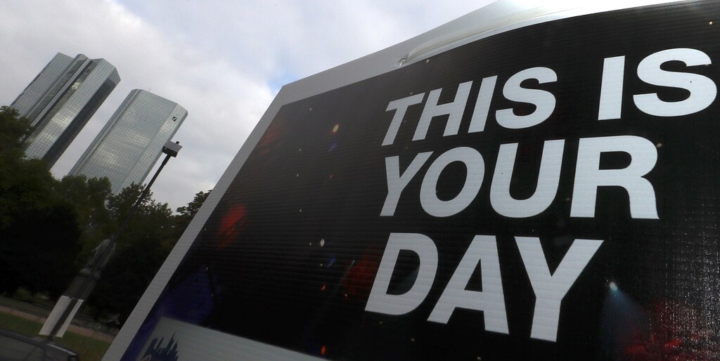 A placard reading "This is your day" is seen on a lamp post next to the head quarter of Germany's largest business bank, Deutsche Bank in Frankfurt, Germany, October 27, 2016. REUTERS/Kai Pfaffenbach - RTX2QOOB