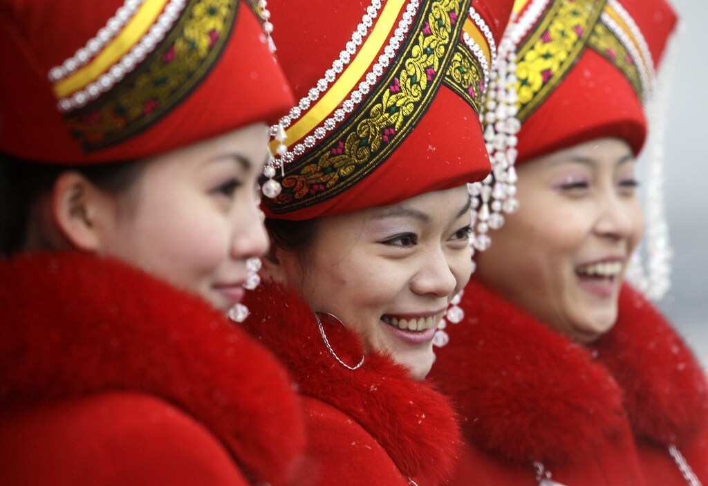 Attendants stand in a line to pose for a picture outside the Great Hall of the People in Beijing, during the second plenary meeting of China's parliament, the National People's Congress (NPC) March 8, 2010. REUTERS/Jason Lee (CHINA - Tags: POLITICS SOCIETY ENVIRONMENT) - RTR2BCXK