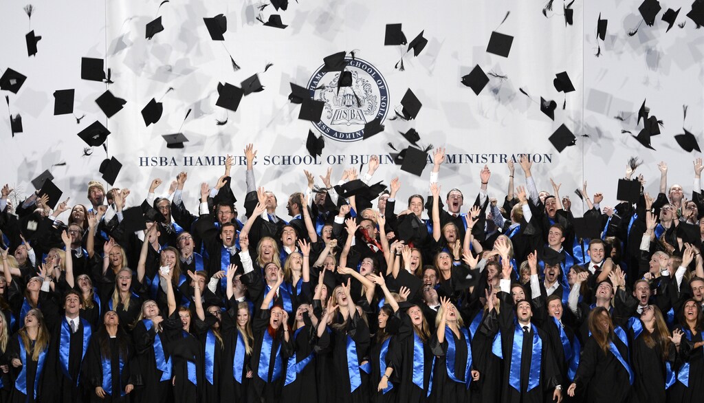 Students throw their hats after the graduation ceremony at the Hamburg School of Business Administration in Hamburg, September 26, 2012.