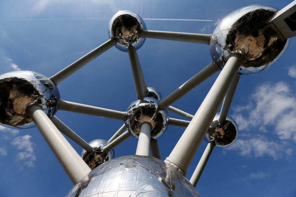 A plane flies over Brussels' Atomium building, a metal structure built in the form of a crystal of iron, at the opening of the exhibition on Belgian surrealist painter Rene Magritte, Belgium September 21, 2017. REUTERS/Francois Lenoir/www.atomium.be-SABAM Belgium 2017 EDITORIAL USE ONLY, NOT FOR SALE FOR MARKETING OR ADVERTISING CAMPAIGNS. NO RESALES. - RC1E5BD11460