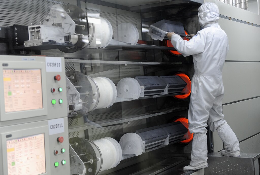 An employee takes out solar panels from an high temperature device at a workshop in Chint Solar Co. Ltd. factory in Hangzhou, Zhejiang province February 10, 2010: Biomanufacturing is shifting from niche climate solution to being foundational to the global economy