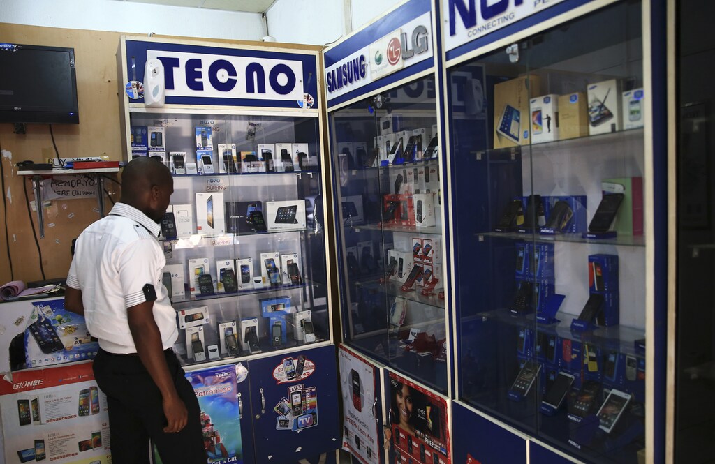 A man looks at smartphones on display at a shop at Wuse II business district in Abuja December 9, 2014. Nigeria is suffering from a plummeting currency, steep budget cuts, corruption scandals and diving oil prices; yet all this is unlikely to decide a tight race for the presidency. When the central bank devalued the naira last month to save foreign reserves, the impact was felt instantly on the streets. Nigeria imports 80 percent of what it consumes. Picture taken December 9, 2014. REUTERS/Afolabi Sotunde (NIGERIA - Tags: BUSINESS POLITICS) - GM1EACF16MS01