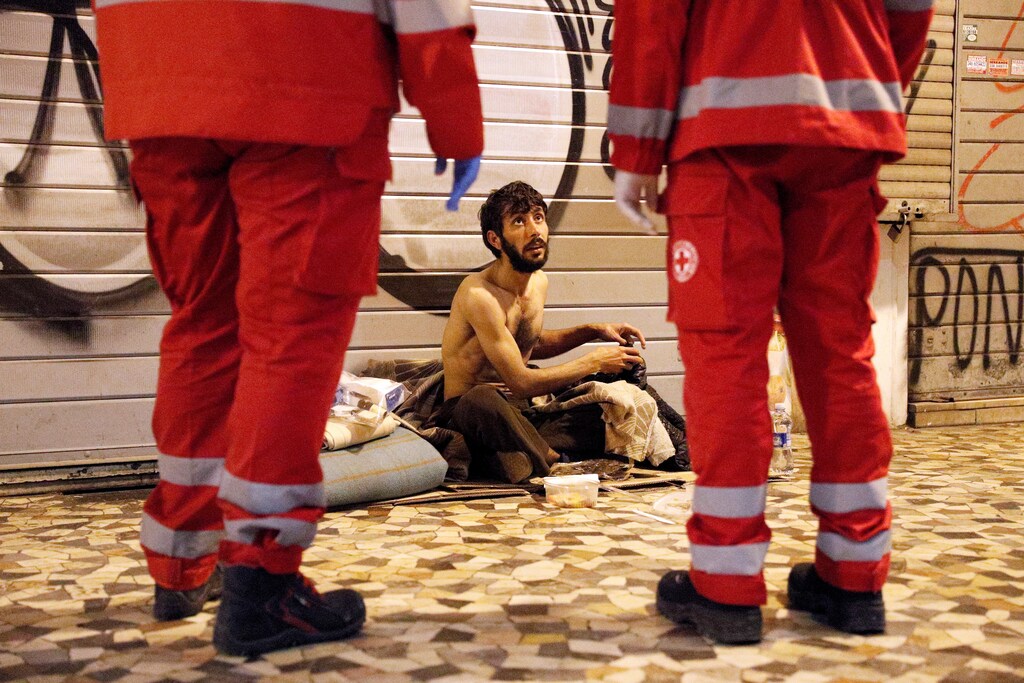 A homeless person talks to Red Cross workers in Rome, Italy, March 17, 2020. Since the coronavirus crisis, Red Cross workers have been increasing their daily activities to meet the growing needs of the homeless in Rome. With nobody around on the streets to give them food or money, and restaurants that would usually donate leftovers closed, homeless are struggling to find food and other supplies to keep them going. REUTERS/Guglielmo Mangiapane Coronavirus china virus health healthcare who world health organization disease deaths pandemic epidemic worries concerns Health virus contagious contagion viruses diseases disease lab laboratory doctor health dr nurse medical medicine drugs vaccines vaccinations inoculations technology testing test medicinal biotechnology biotech biology chemistry physics microscope research influenza flu cold common cold bug risk symptomes respiratory china iran italy europe asia america south america north washing hands wash hands coughs sneezes spread spreading precaution precautions health warning covid 19 cov SARS 2019ncov wuhan sarscow wuhanpneumonia pneumonia outbreak patients unhealthy fatality mortality elderly old elder age serious death deathly deadly