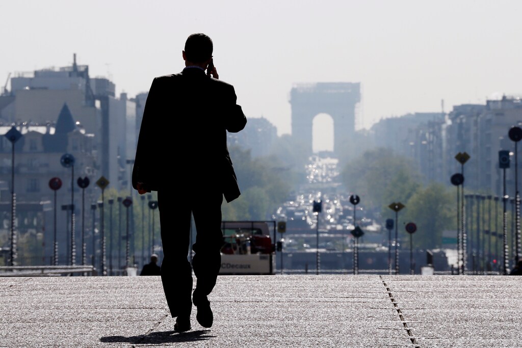 A businessman walks on the esplanade of La Defense.
