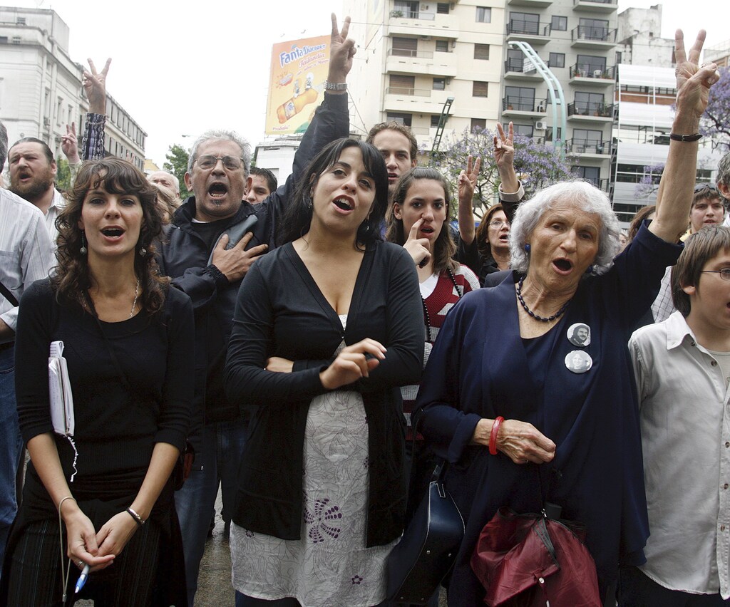 Argentina's newly-elected congresswoman Victoria Donda Perez (C) takes part in a political rally in front of the Naval Mechanics School building, Argentina's infamous torture center also known as ESMA, in Buenos Aires November 17, 2007. Donda, born to political prisoners during Argentina's dirty war then illegally adopted and robbed of her identity, swears to deepen the country's commitment to human rights when she takes her new seat in Congress next week. Of more than 80 people who have recovered their identities after being born in captivity during the 1976-1983 military dictatorship and then adopted by military families or their friends, Donda is the first to become a lawmaker. Picture taken November 17. REUTERS/Enrique Marcarian (ARGENTINA) - GM1DWRUSJJAA