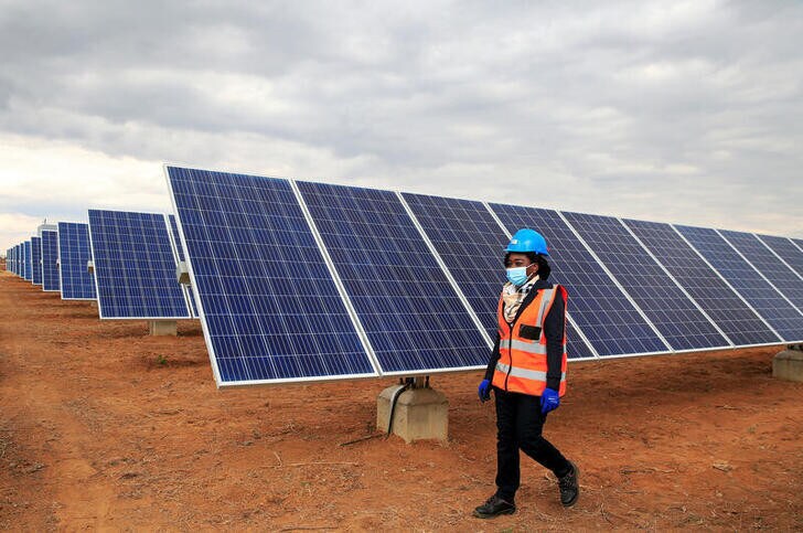 A worker walks past solar panels at Centragrid power plant in Nyabira, Zimbabwe, June 22, 2020. Picture taken June 22, 2020. REUTERS/Philimon Bulawayo