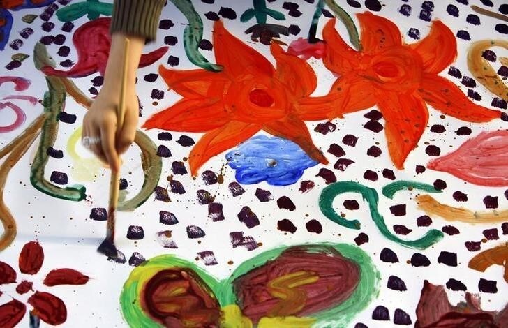 A Romanian child paints a flower on the world longest painting ever made by children, a Guinness Book record, in Bucharest November 18, 2006. REUTERS/Bogdan Cristel (ROMANIA)