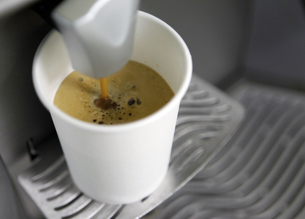 A coffee machine pours coffee into a paper cup in Kiev March 1, 2012. REUTERS/Gleb Garanich (UKRAINE - Tags: FOOD) - RTR2YP01