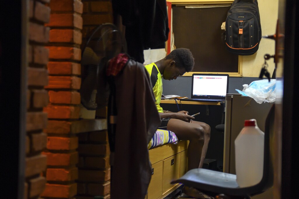 Boubacar Bocoum, 26, a student from Mali, seats on his bed and chats on his phone at the Fondation 2iE, an engineering school, during lockdown at the university campus to limit the spread of coronavirus disease (COVID-19), in Ouagadougou, Burkina Faso April 1, 2020. Picture taken April 1, 2020. Reuters/Anne Mimault - RC2JWF9GA637