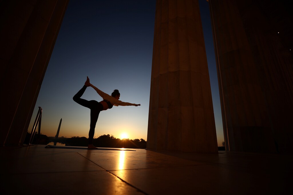 A woman exercises on the steps of the Lincoln Memorial during sunrise in Washington, U.S., November 7, 2020. A new study suggests Americans are less active than their ancestors. REUTERS/Hannah McKay