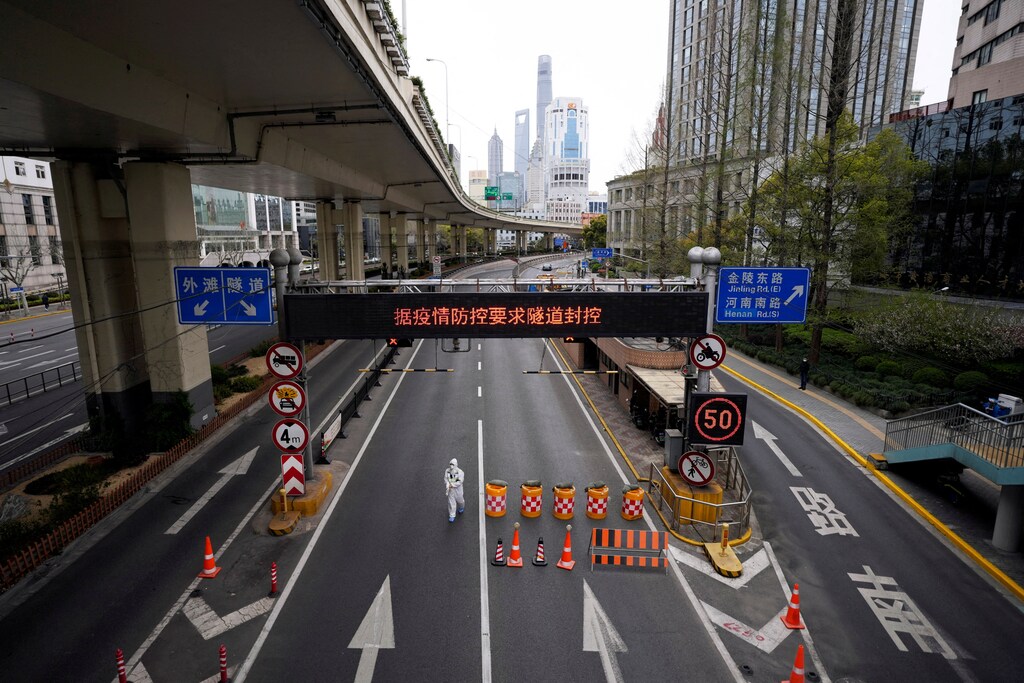 A worker in a protective suit walks at an entrance to a tunnel leading to the Pudong area across the Huangpu river, after restrictions on highway traffic amid the lockdown to contain the spread of the coronavirus disease (COVID-19) in Shanghai, China March 28, 2022. REUTERS/Aly Song TPX IMAGES OF THE DAY