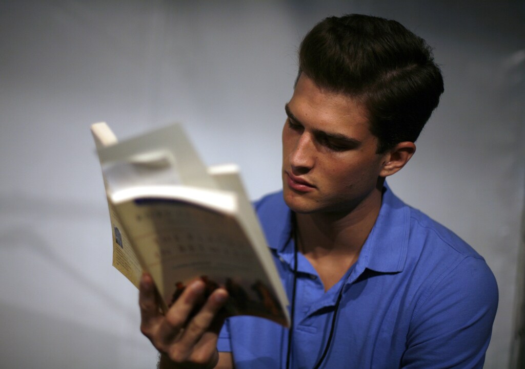 A model reads a book prior to the Spring 2008 Duckie Brown collection during New York Fashion Week September 5, 2007. REUTERS/Eric Thayer (UNITED STATES) - GM1DWBZZALAA