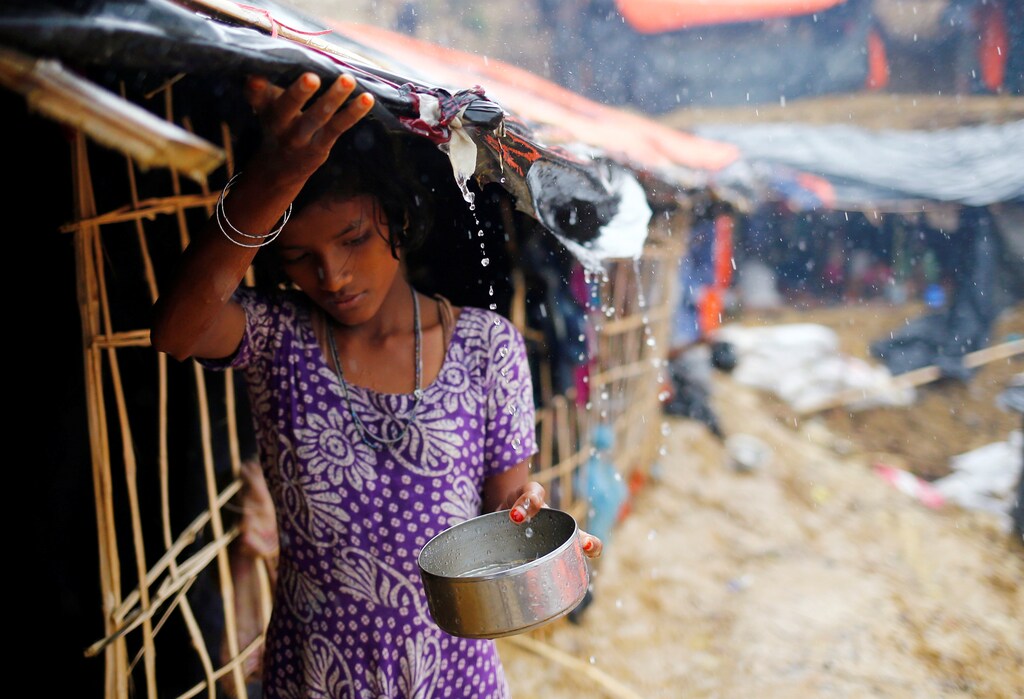 A Rohingya refugee girl collects rain water at a makeshift camp in Cox's Bazar, Bangladesh, September 17, 2017. REUTERS/Mohammad Ponir Hossain - RC11151BEFF0