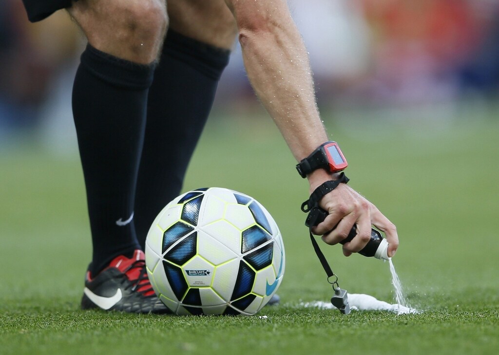 Match referee Jon Moss uses vanishing spray to mark the boundary of the ball during a free kick in the English Premier League soccer match between Arsenal and Crystal Palace at the Emirates stadium in London August 16, 2014. REUTERS/Stefan Wermuth (BRITAIN - Tags: SPORT SOCCER) FOR EDITORIAL USE ONLY. NOT FOR SALE FOR MARKETING OR ADVERTISING CAMPAIGNS. NO USE WITH UNAUTHORIZED AUDIO, VIDEO, DATA, FIXTURE LISTS, CLUB/LEAGUE LOGOS OR "LIVE" SERVICES. ONLINE IN-MATCH USE LIMITED TO 45 IMAGES, NO VIDEO EMULATION. NO USE IN BETTING, GAMES OR SINGLE CLUB/LEAGUE/PLAYER PUBLICATIONS - RTR42NSG