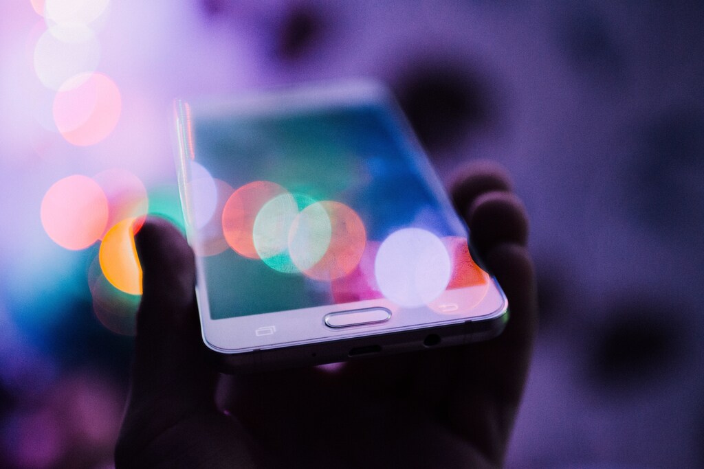 A hand holds a mobile phone as issues remain about the implementation of digital ID systems