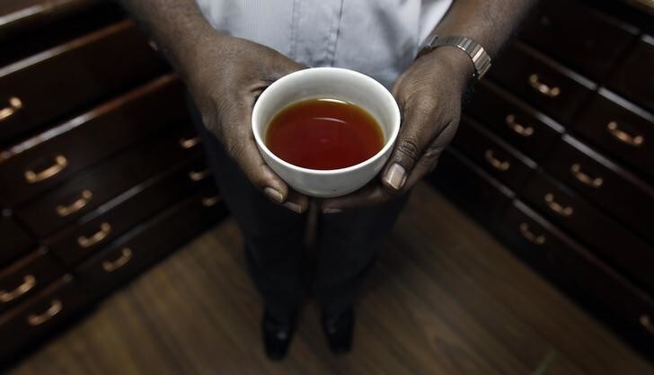 A worker shows a cup of tea, after it has been tested, in a tea room at a tea factory in Colombo June 20, 2013. Sri Lanka's May tea production rose 2.9 percent from a year earlier, extending its rise for the sixth straight month, data from the state-run Tea Board showed on Thursday, with favourable weather helping boost production throughout the year.REUTERS/Dinuka Liyanawatte (SRI LANKA - Tags: BUSINESS)