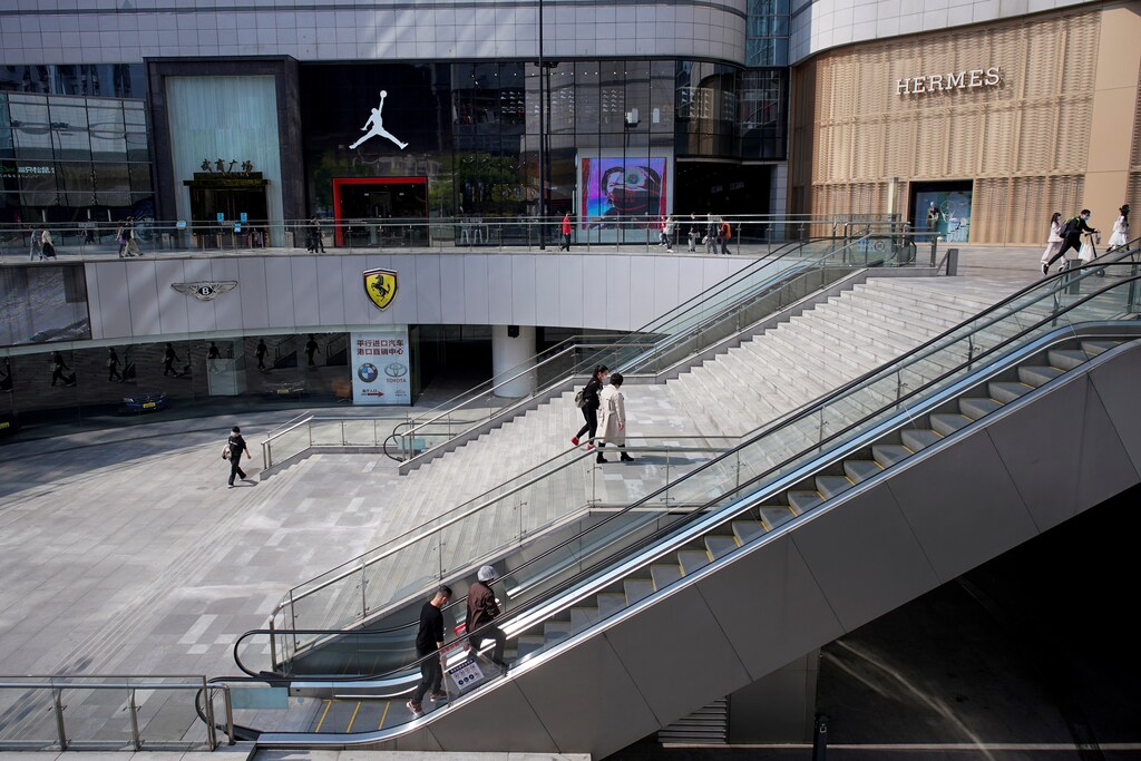 People wearing face masks walk through a shopping mall after lockdown in Wuhan, the epicentre of China's novel coronavirus disease (COVID-19) outbreak, is lifted, in Wuhan, Hubei province, China, April 9, 2020.