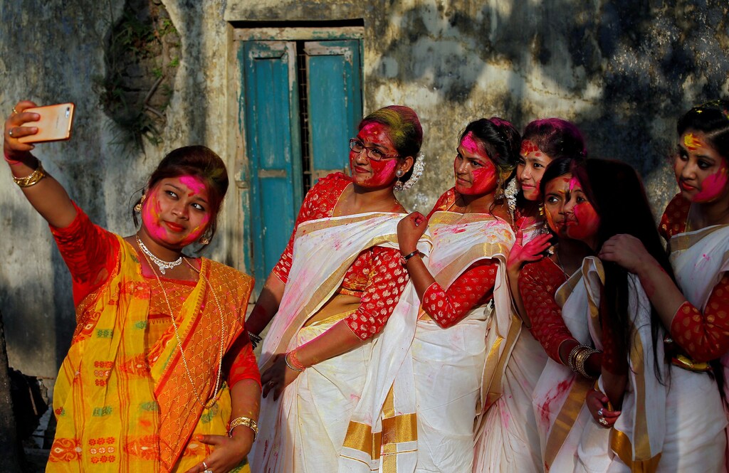 Students of Rabindra Bharati University, with their faces smeared in coloured powder, take a selfie during celebrations for Holi inside the university campus in Kolkata, India, February 26, 2018. REUTERS/Rupak De Chowdhuri TPX IMAGES OF THE DAY - RC15DC63A560