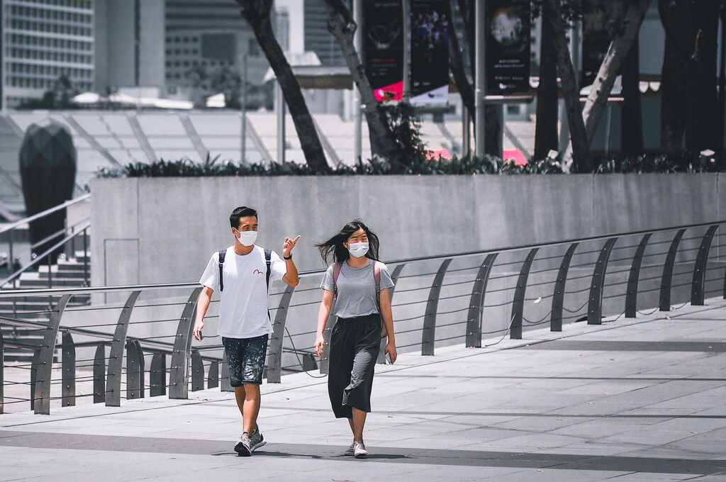 Two young Asians walking down a street in Singapore.