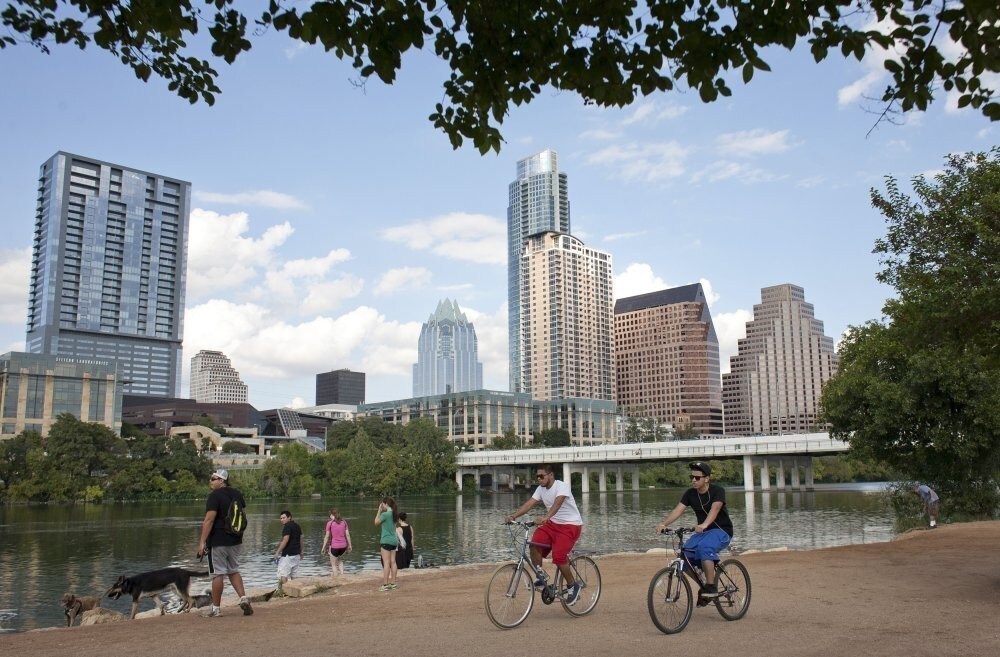Cyclists pass beneath the downtown skylone