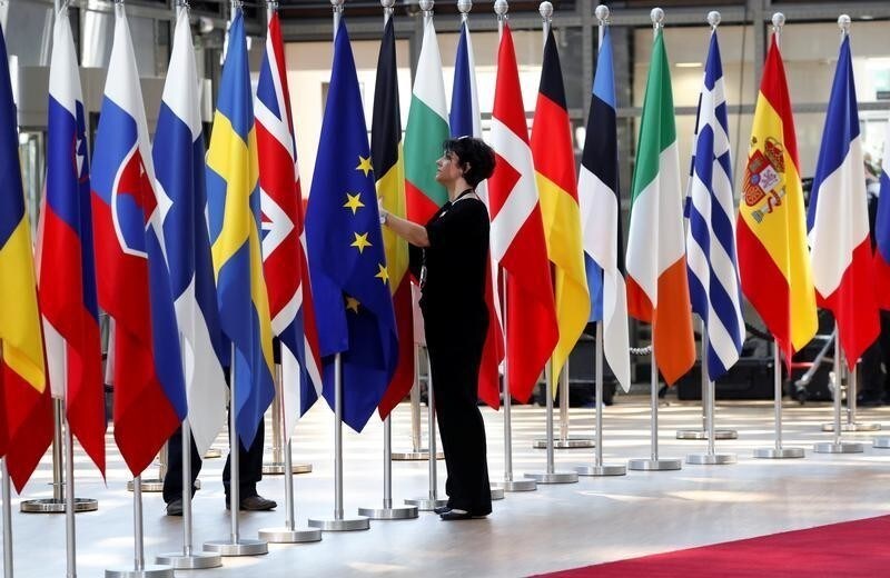 A woman adjusts flags ahead of European Union summit in Brussels, Belgium June 28, 2018. REUTERS/Yves Herman - RC126CC1E8A0