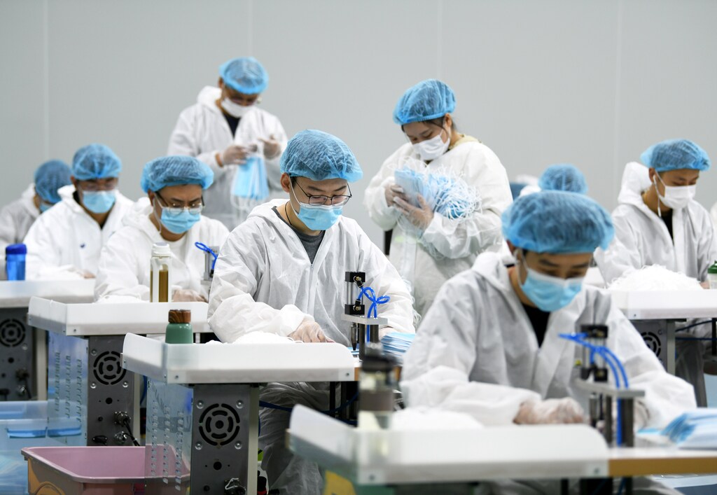 Employees work on a production line of surgical masks for export, at a railway equipment manufacturing company in Nanchang, Jiangxi province, China April 8, 2020. Picture taken April 8, 2020. China Daily via REUTERS ATTENTION EDITORS - THIS IMAGE WAS PROVIDED BY A THIRD PARTY. CHINA OUT. - RC2U0G91RT4J