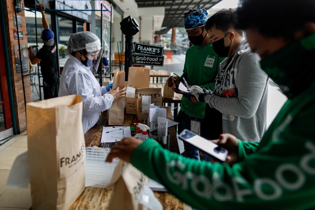 A restaurant worker wearing personal protective equipment prepares orders for delivery riders outside a restaurant amid the coronavirus disease (COVID-19) outbreak , in Quezon City, Metro Manila, Philippines, July 8, 2020. REUTERS/Eloisa Lopez - RC2XOH9VMBAI