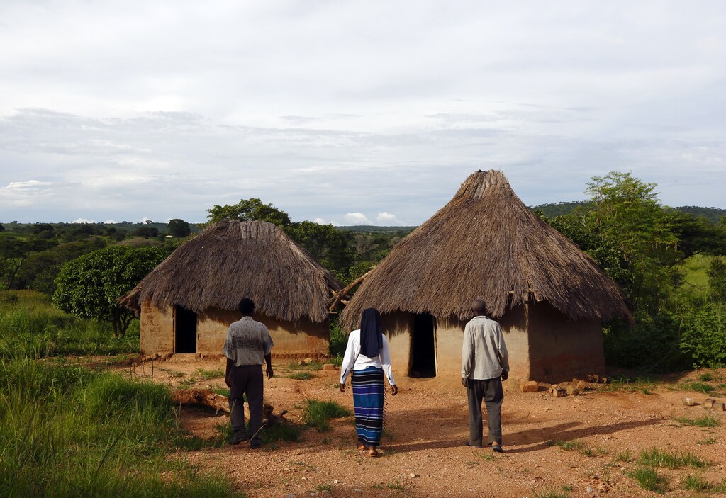 HIV-positive 71-year-old Sylverio Hachiploa (right) walks with caregivers Glandwel Muleya (L) and Sister Abigail Mwaka Mazuba (C) during a visit by a home-based care team in the village of Nedwmba, south of the Chikuni Mission in the south of Zambia February 23, 2015. The caregivers in the Jesuit-run home-based care project at the Chikuni Mission run a capacity-building and empowerment project at the household level, offering training and assistance in crop-growing and animal rearing, as well as offering companionship, pastoral care and monitoring of the antiretroviral treatment compliance of HIV-AIDS patients. REUTERS/Darrin Zammit Lupi (ZAMBIA - Tags: SOCIETY HEALTH) - GM1EB2O0EE401