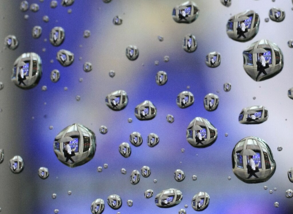 Rain drops on a car window reflects a man walking past a stock index board in Tokyo August 10, 2009. The Nikkei average hit its highest close in 10 months on Monday, buoyed by stronger-than-expected U.S. jobs data and a report that Mitsubishi Chemical was in talks to acquire resin maker Mitsubishi Rayon. The image was rotated 180 degree. REUTERS/Kim Kyung-Hoon (JAPAN BUSINESS IMAGES OF THE DAY) - GM1E58A16UP01